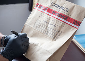 hand-in-glove-writing-on-evidence-bag